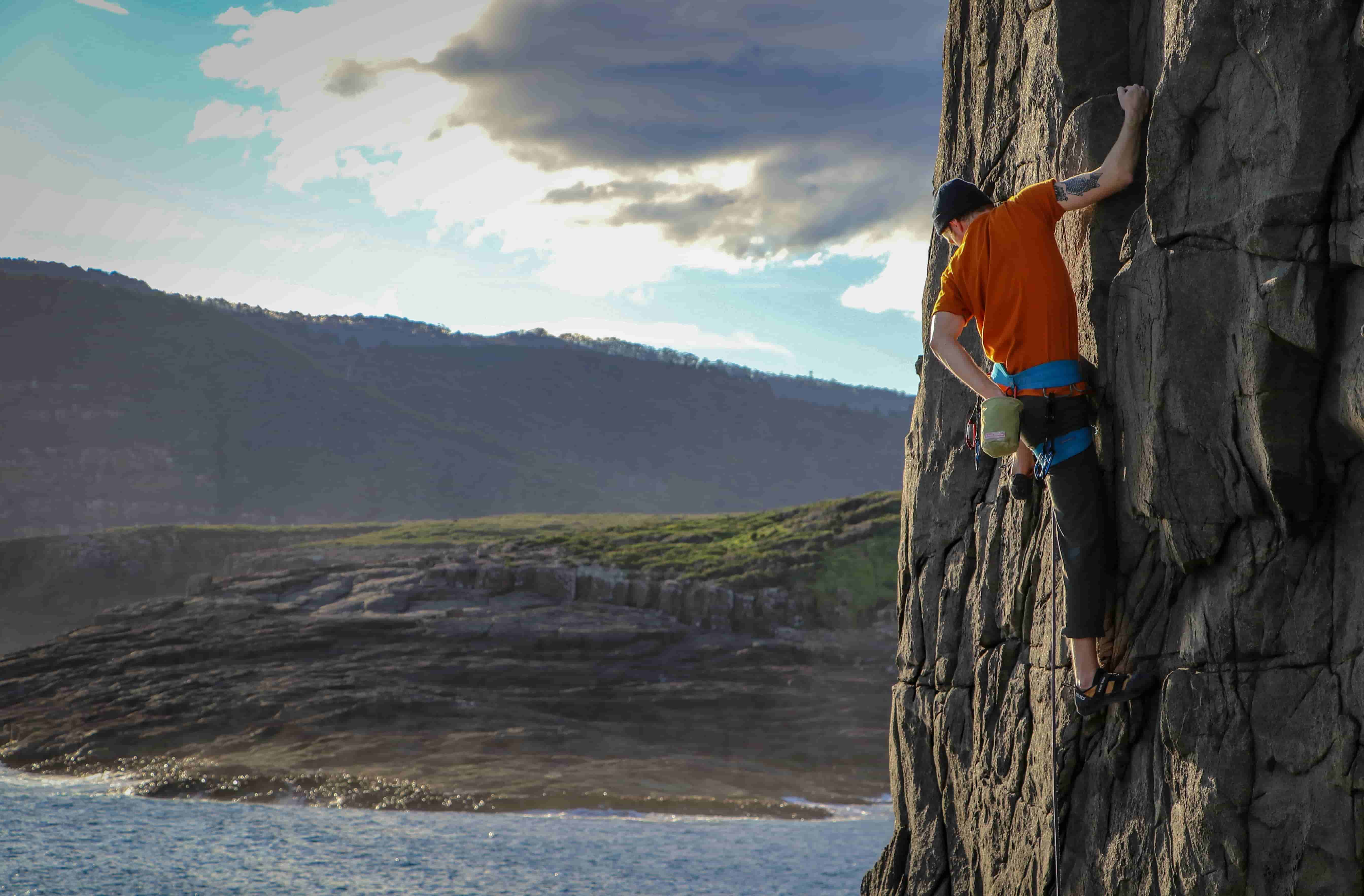 Stan scaling the wall of a canyon mountain.